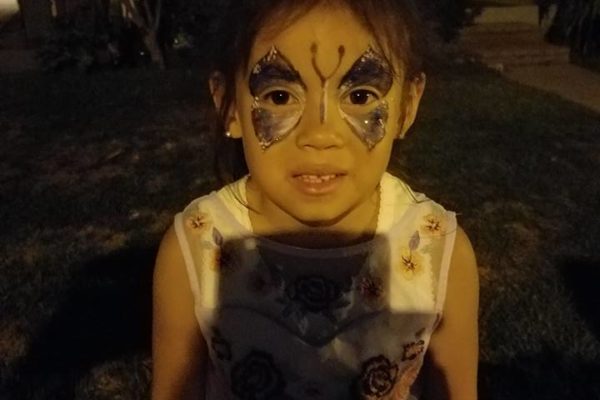 A little gril shown her face painting in front of her home - Joy of Life Surrogacy