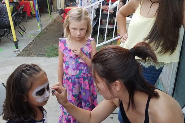Joy of Life employee give face painting to a little girl - Joy of Life Surrogacy