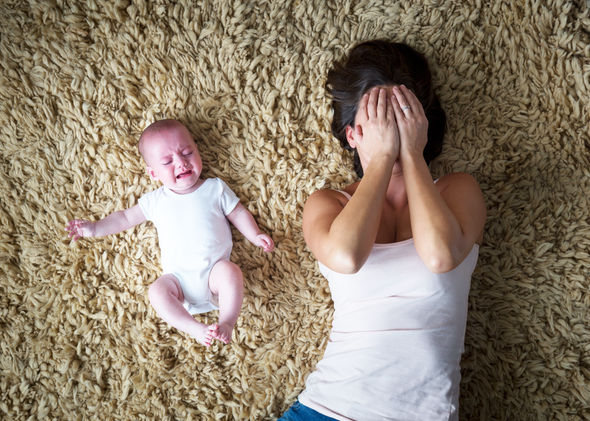 Newborn baby and his mom laying on the ground