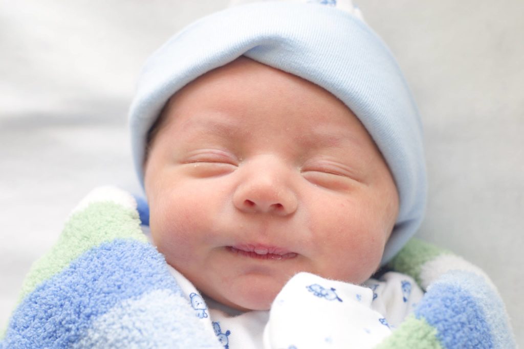 newborn baby smiling - Joy of Life Surrogacy