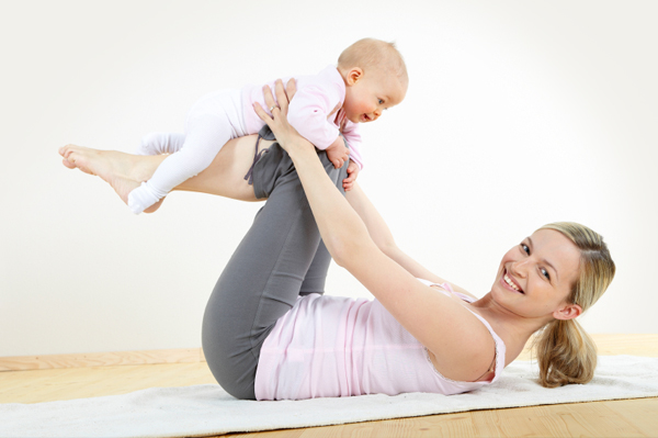 A mother is working on yoga with her newborn baby - Joy of Life Surrogacy