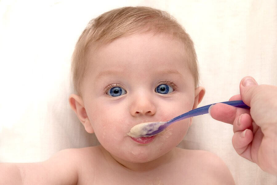 A blue-eyes newborn baby was eating his baby food - Joy of Life Surrogacy