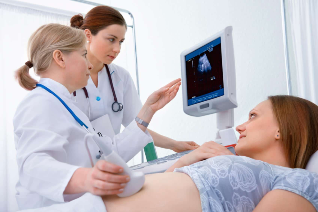 2 doctor testing baby's position in the womb - Joy of Life Surrogacy