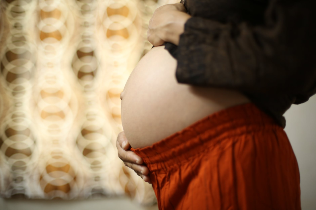 A pregnant mom touching her belly - Joy of Life Surrogacy